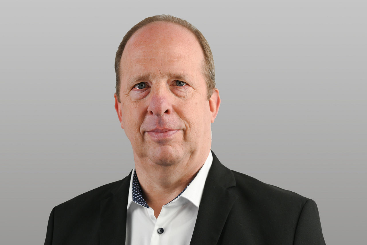 Firmenkundenberater Ludger Holz vor grauem Hintergrund