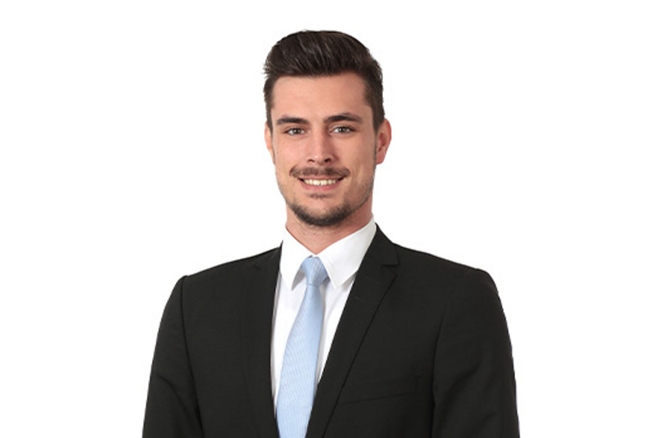 Freundlich lächelnder Mann im Anzug, unser Teamleiter Privatkunden Filip Huber