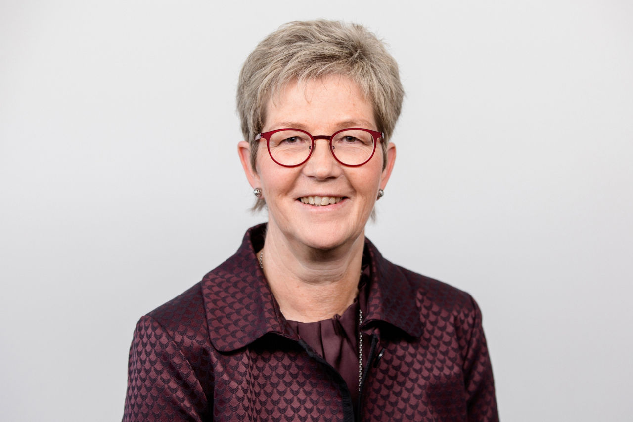 Eine lächelnder Frau schaut in die Kamera.