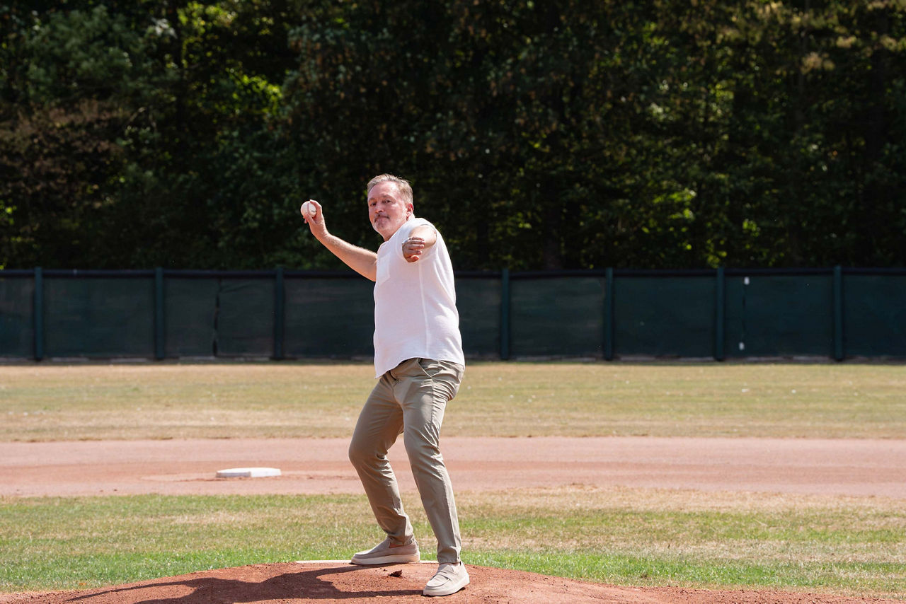 Person die einen Baseball wirft.