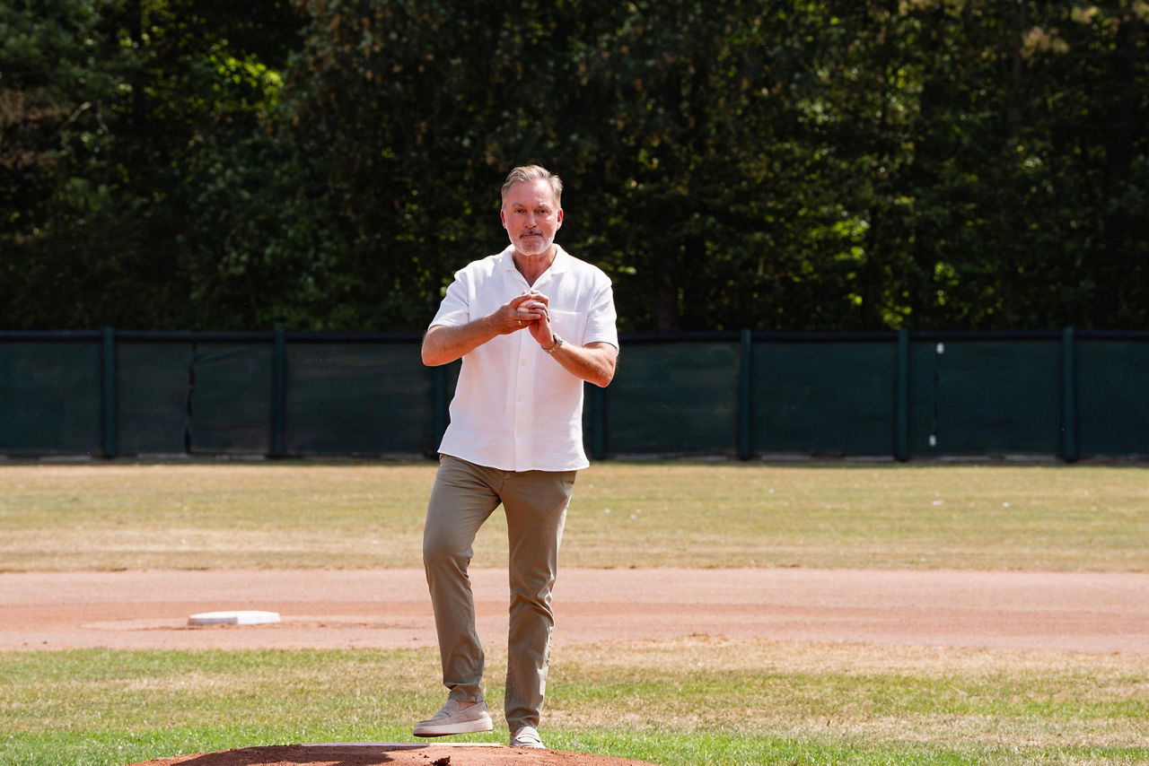 Person die einen Baseball hält