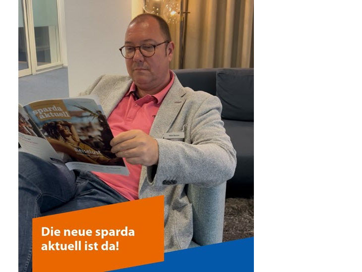 Ein Mann sitzt in einem Sessel und liest eine Ausgabe der sparda aktuell