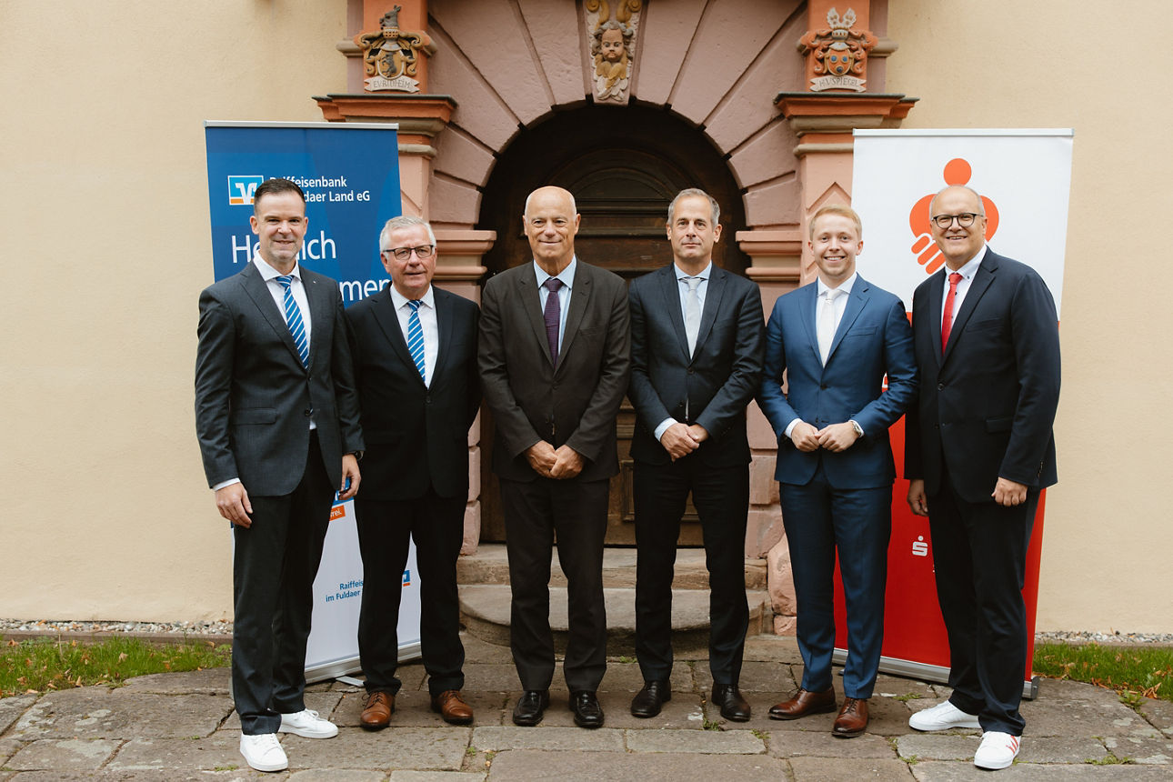 6 Männer stehen vor einem Gebäude