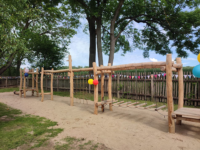 Affengitter aus Holz an einem sonnigen Tag mit Luftballons auf einem Spielplatz