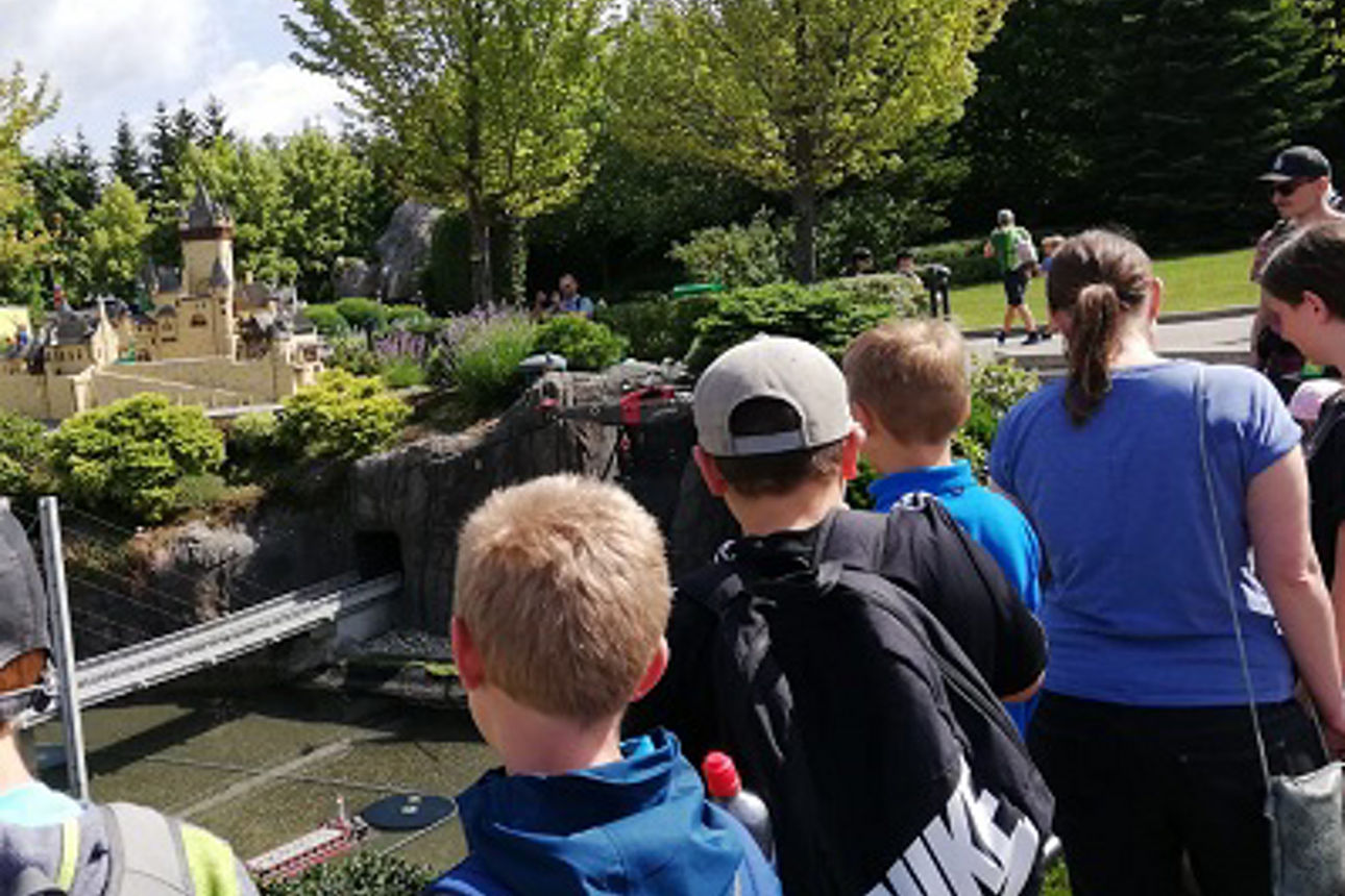 Eine Gruppe Kinder bestaunt eine Miniaturausgabe einer Burg und einer Stadt