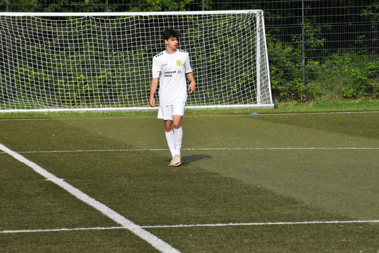 Ein junger Mann steht auf dem Fußballplatz und spielt Fußball.