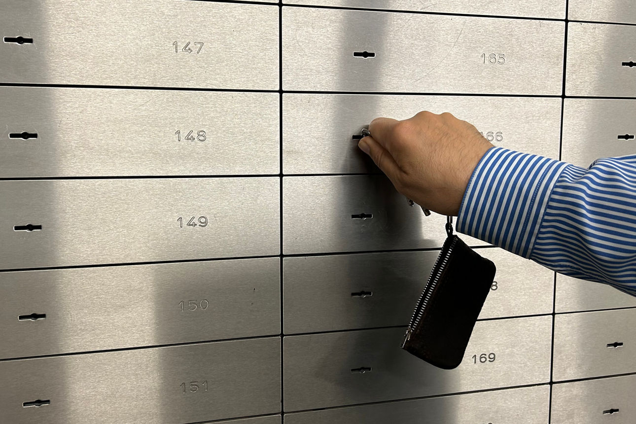 Hand mit Schlüssel am Bankschließfach