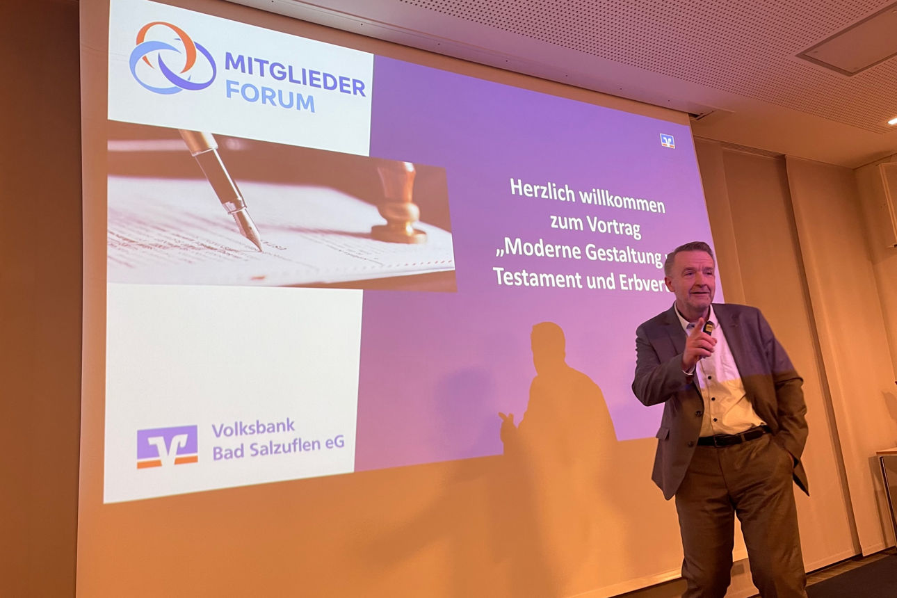 Notar Ulrich Backhaus hält Präsentation vor Leinwand