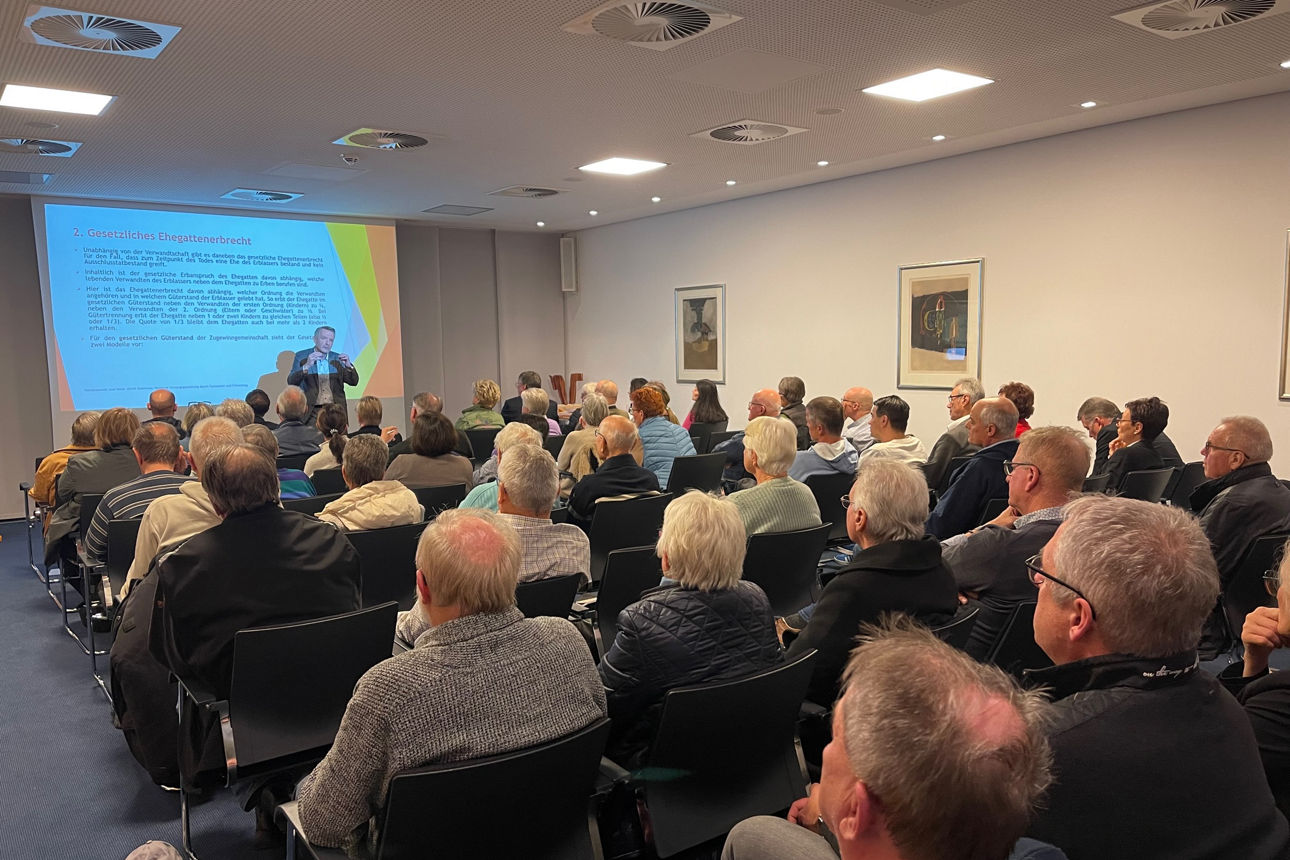 Teilnehmer sehen sich Präsentation auf Leinwand an