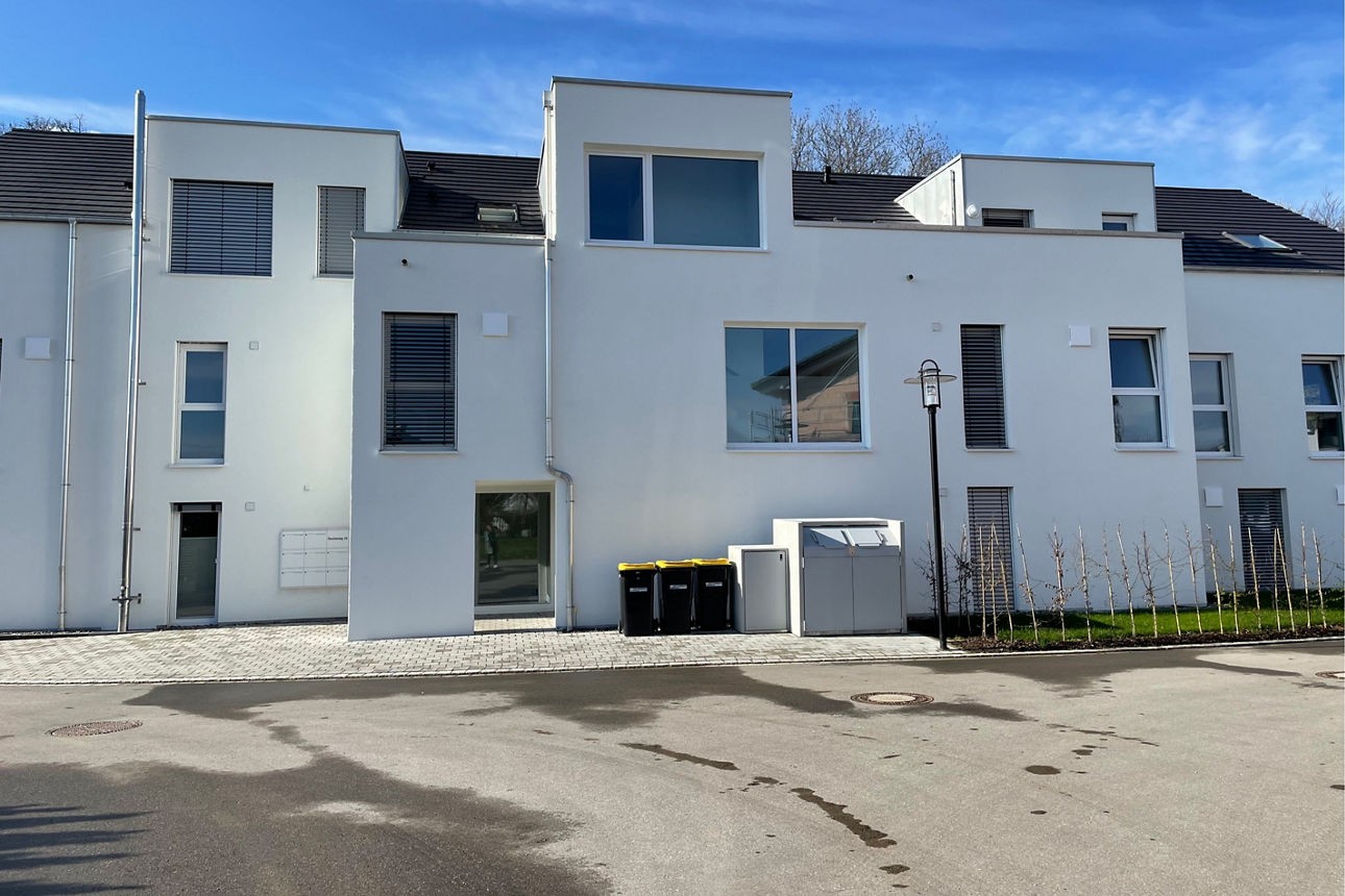 Neubau eines weißen Mehrfamilienhauses.