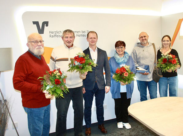 Gewinner stehen lächelnd mit Blumen in der Hand im Beratungszimmer Hemau