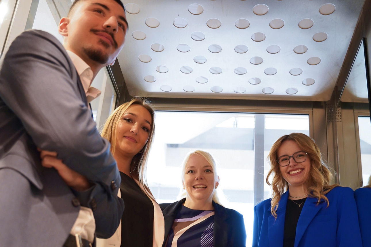 Unsere Personalverantwortliche mit drei Auszubildenden im Fahrstuhl