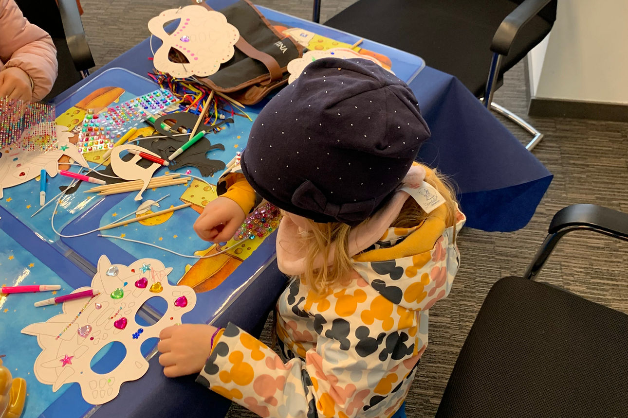 Ein Mädchen steht an einem Basteltisch