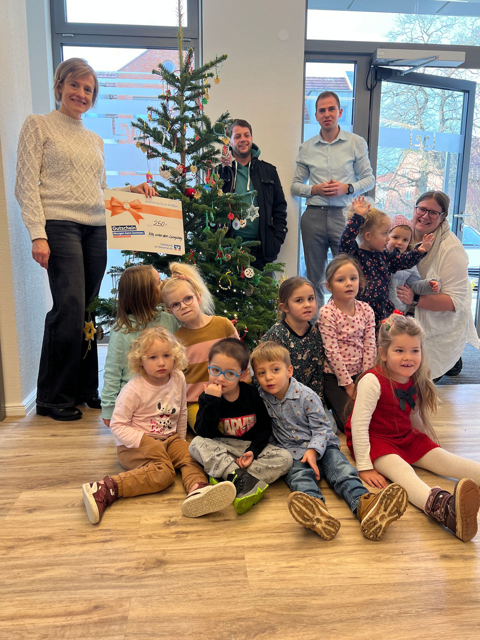 Verschiedene Personen vor einem Weihnachtsbaum