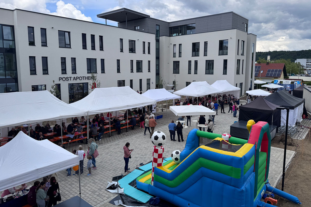 Bild Innenhof VR-Quartier bei Eröffnung mit Hüpfburg, Pavillons und Personen