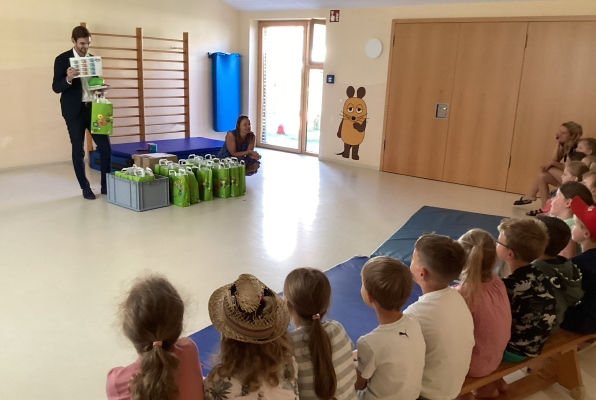 Mann übergibt Diplom an Kinder