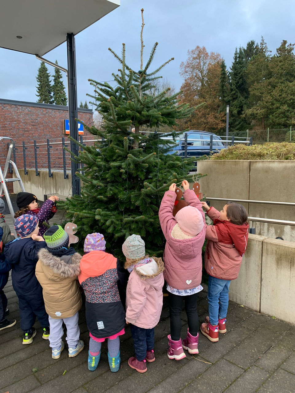 Kinder schmücken einen Weihnachtsbaum