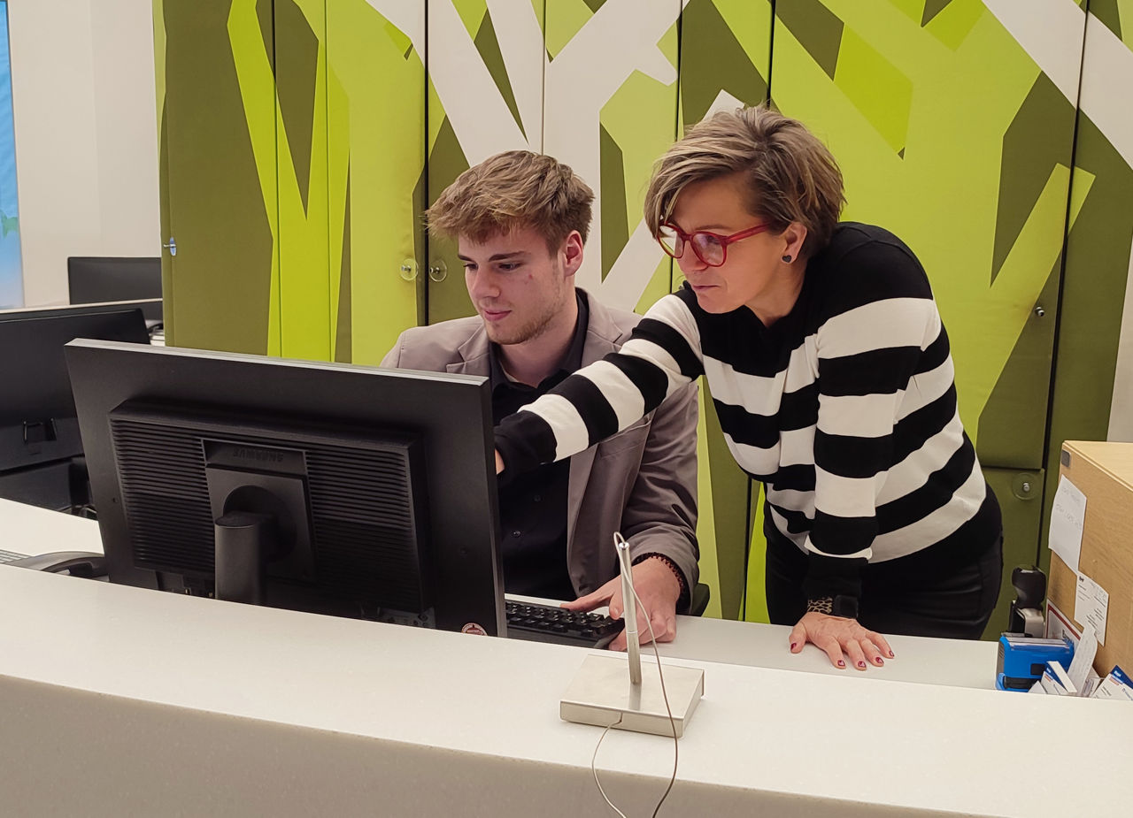 Ein Mann und eine Frau, die an einem Computer zusammenarbeiten und sich auf ihre Arbeit in einer modernen Büroumgebung konzen