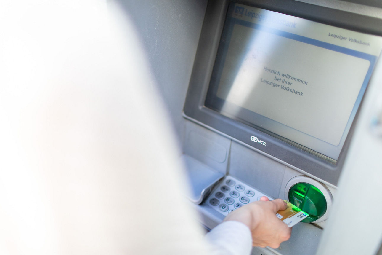 Volksbank-Kundin am Automat mit goldener girocard