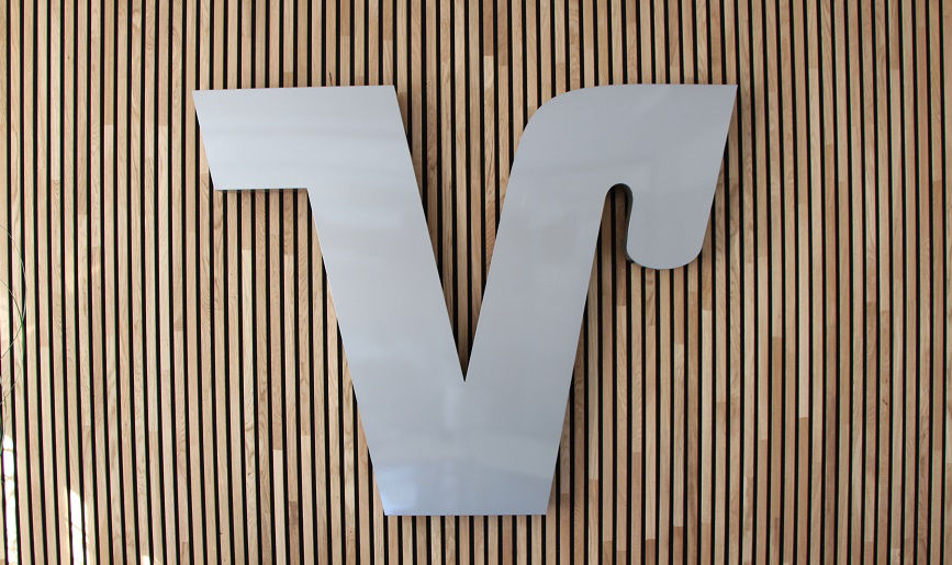Markenzeichen Volksbanken Raiffeisenbanken auf einer Wand aus Holzpaneelen
