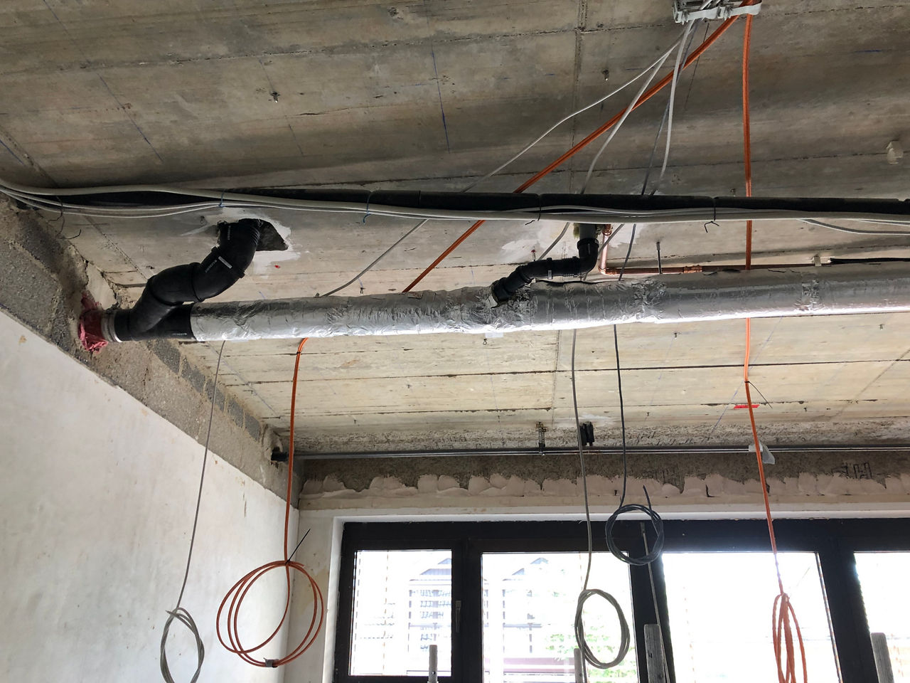 Das Foto zeigt Kabel und Rohre, die an den Decken der Filiale verlegt wurden.