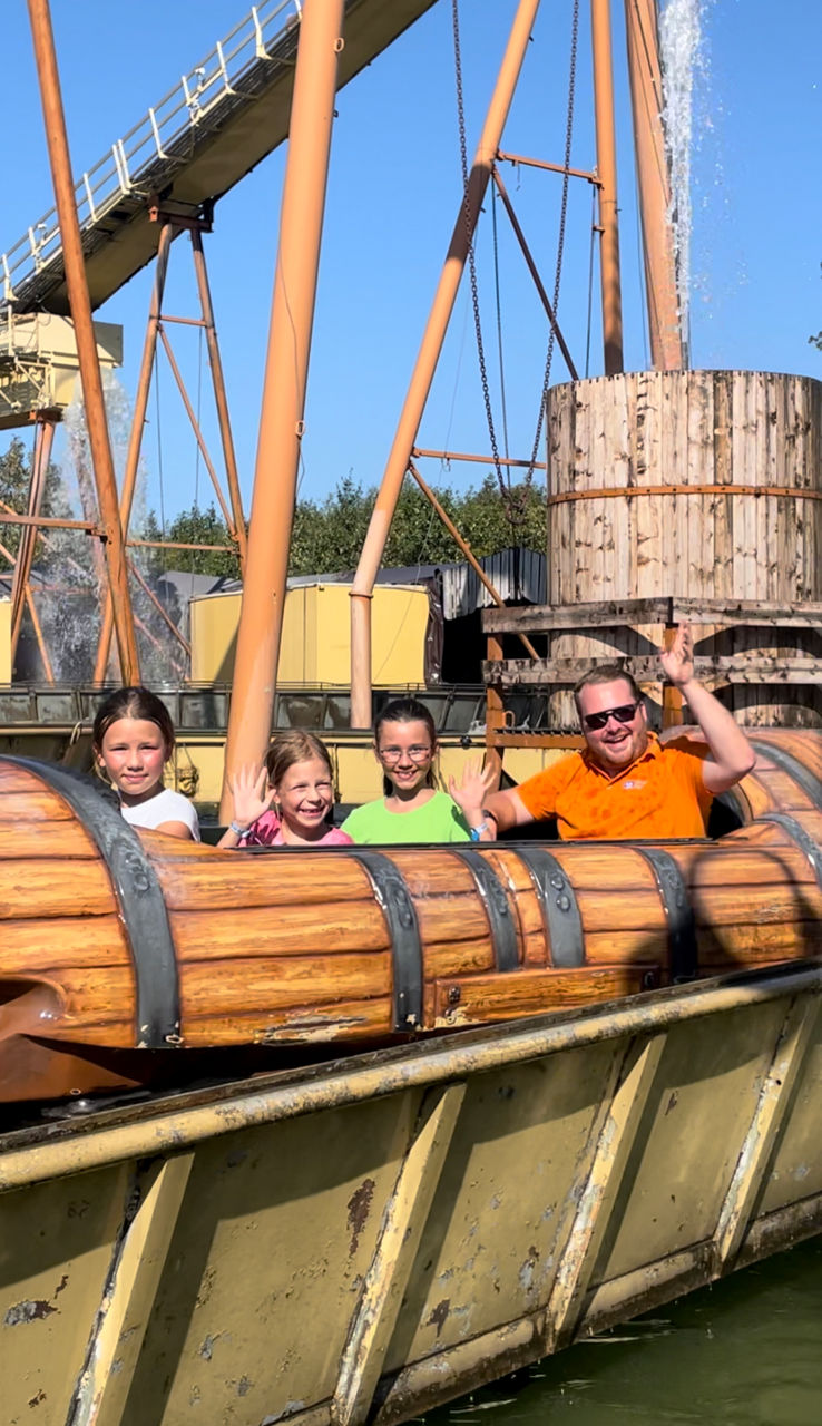 Drei Kinder mit einem Betreuer in einer Wasserbahn