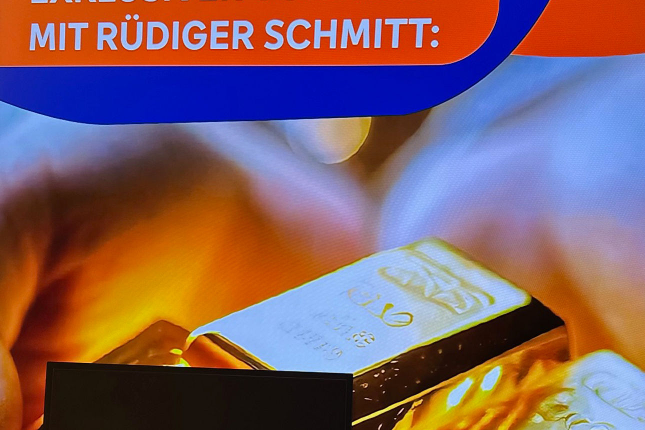 Ankündigung des Vortrags von Rüdiger Schmitt auf einem Display in der Filiale