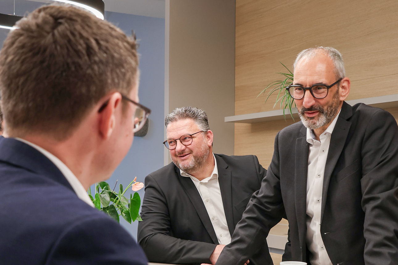 Vier Männer sitzen am Tresen und besprechen sich