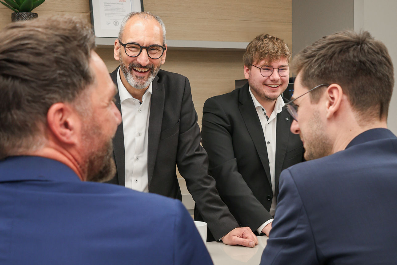 Vier Männer unterhalten sich in der Runde