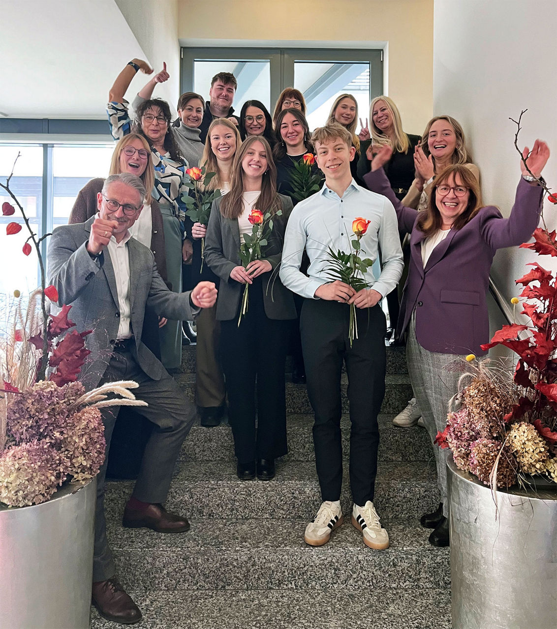 Gruppenfoto im Treppenhaus mit den fertigen Azubis und Mitarbeitenden aus unserer Bank.