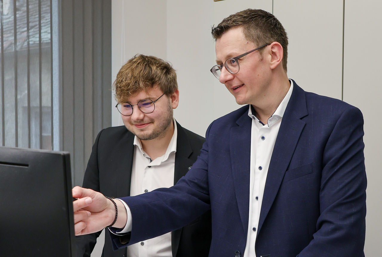 Zwei Männer im Anzug arbeiten gemeinsam im Büro