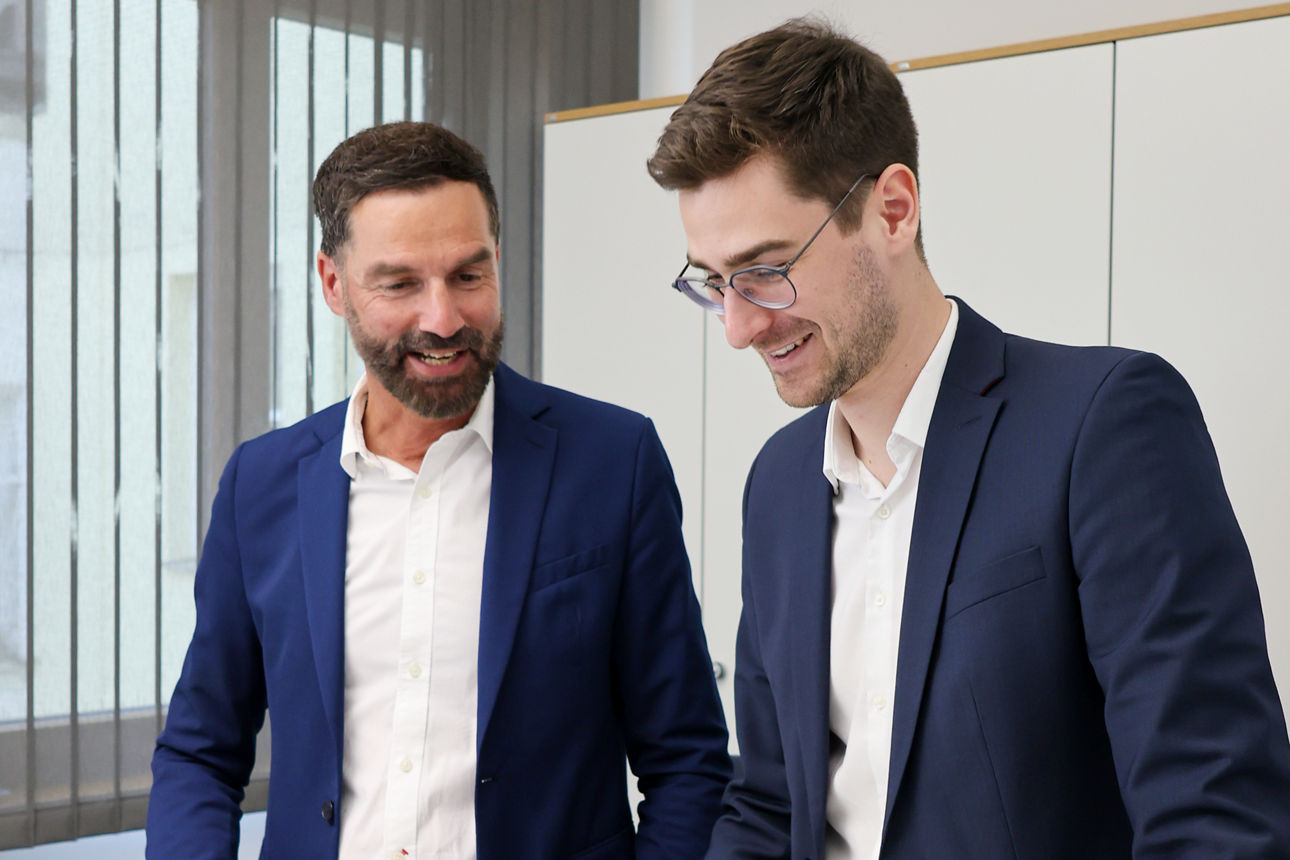 Zwei Männer im Anzug arbeiten zusammen