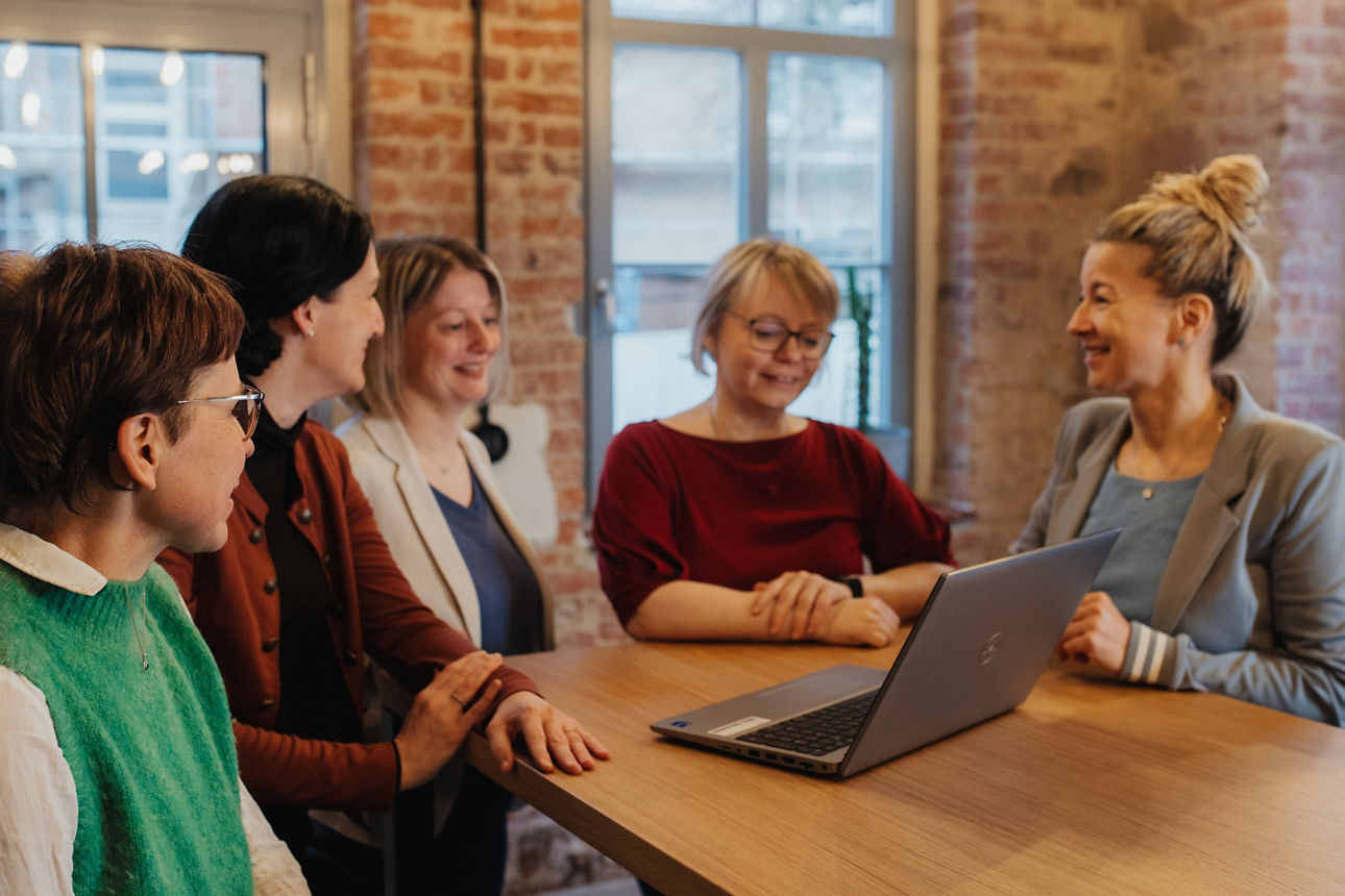 Fünf weibliche Personen sitzen an einem Tisch.