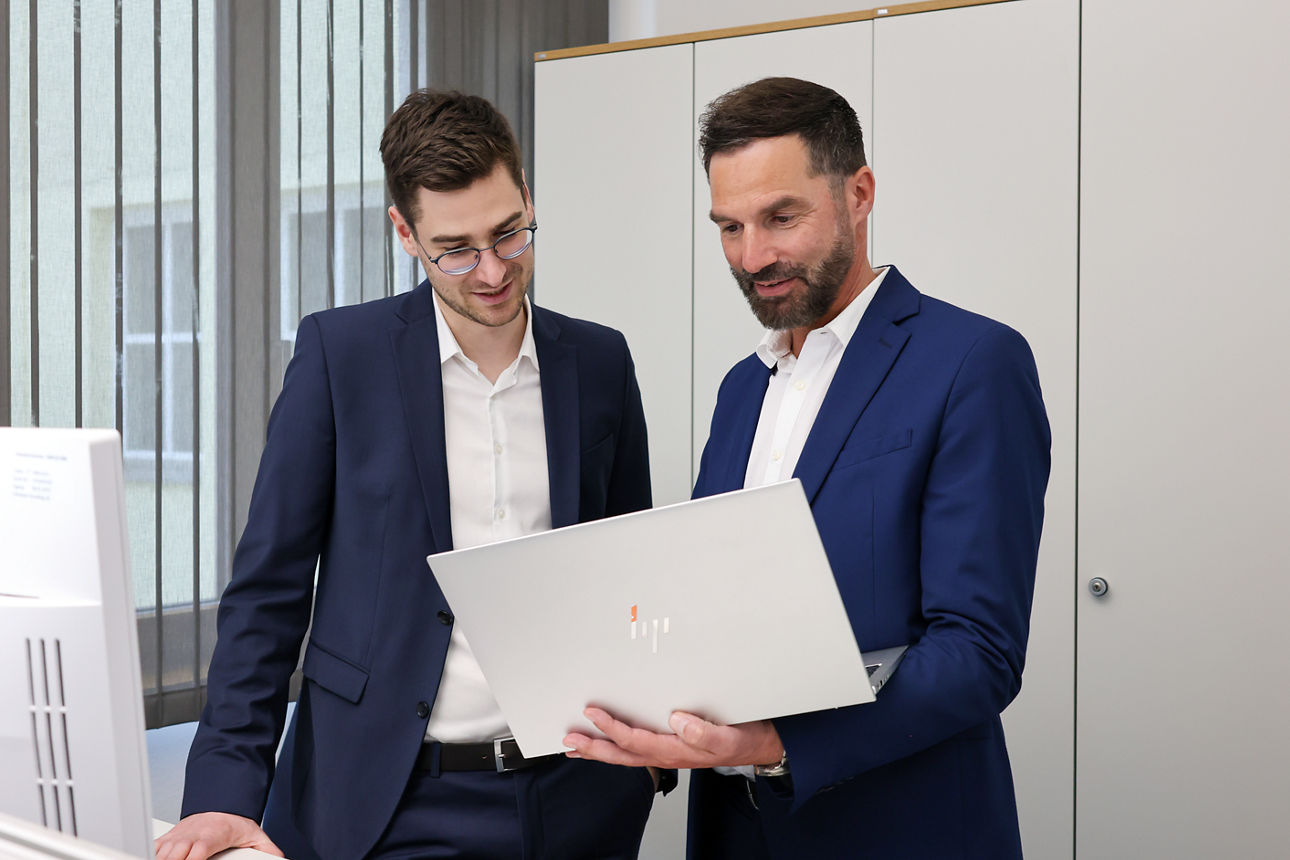 Zwei Männer schauen gemeinsam in einen Laptop