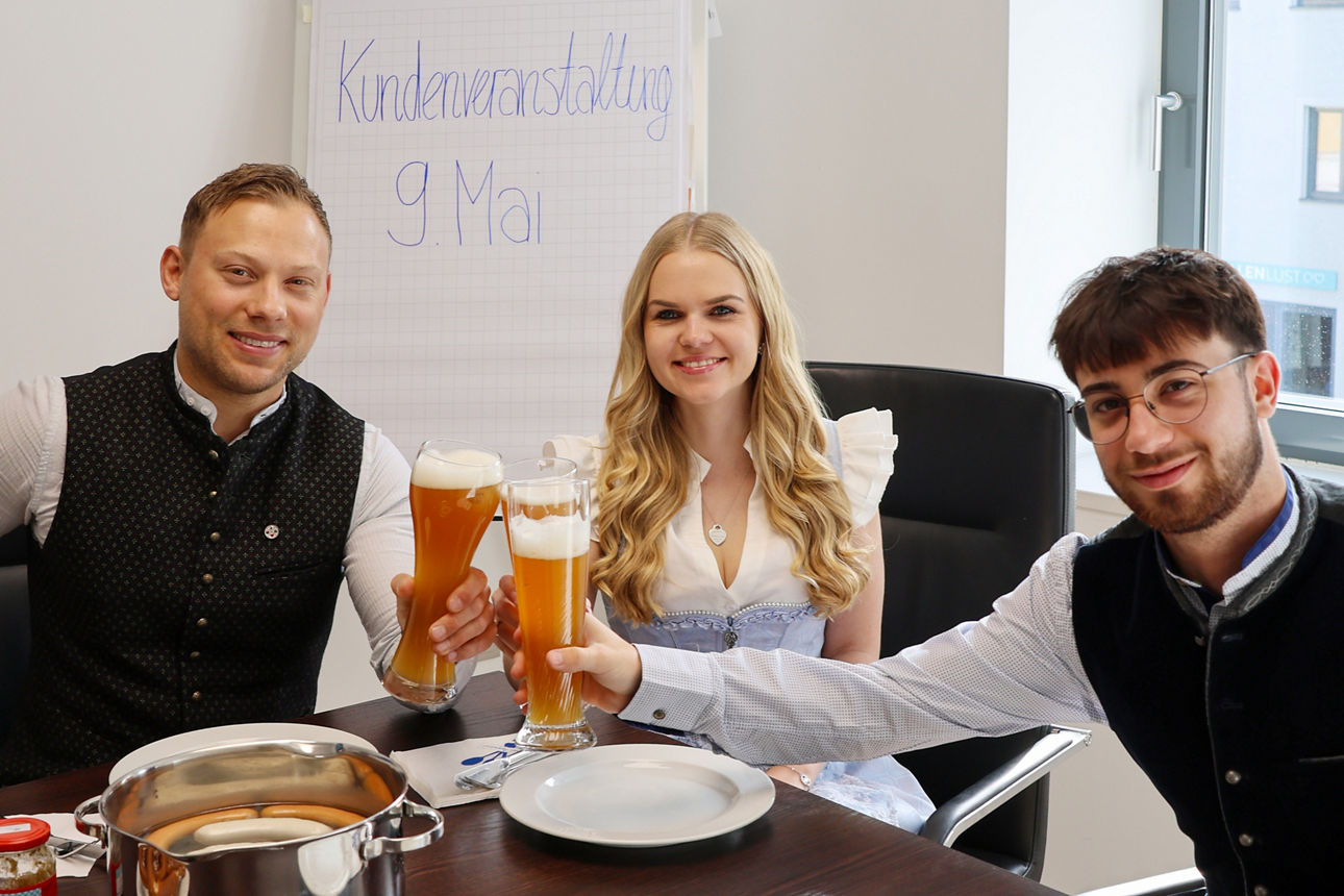 Brezen, Weißwurst, Bier und ein Bauplan auf einem Tisch