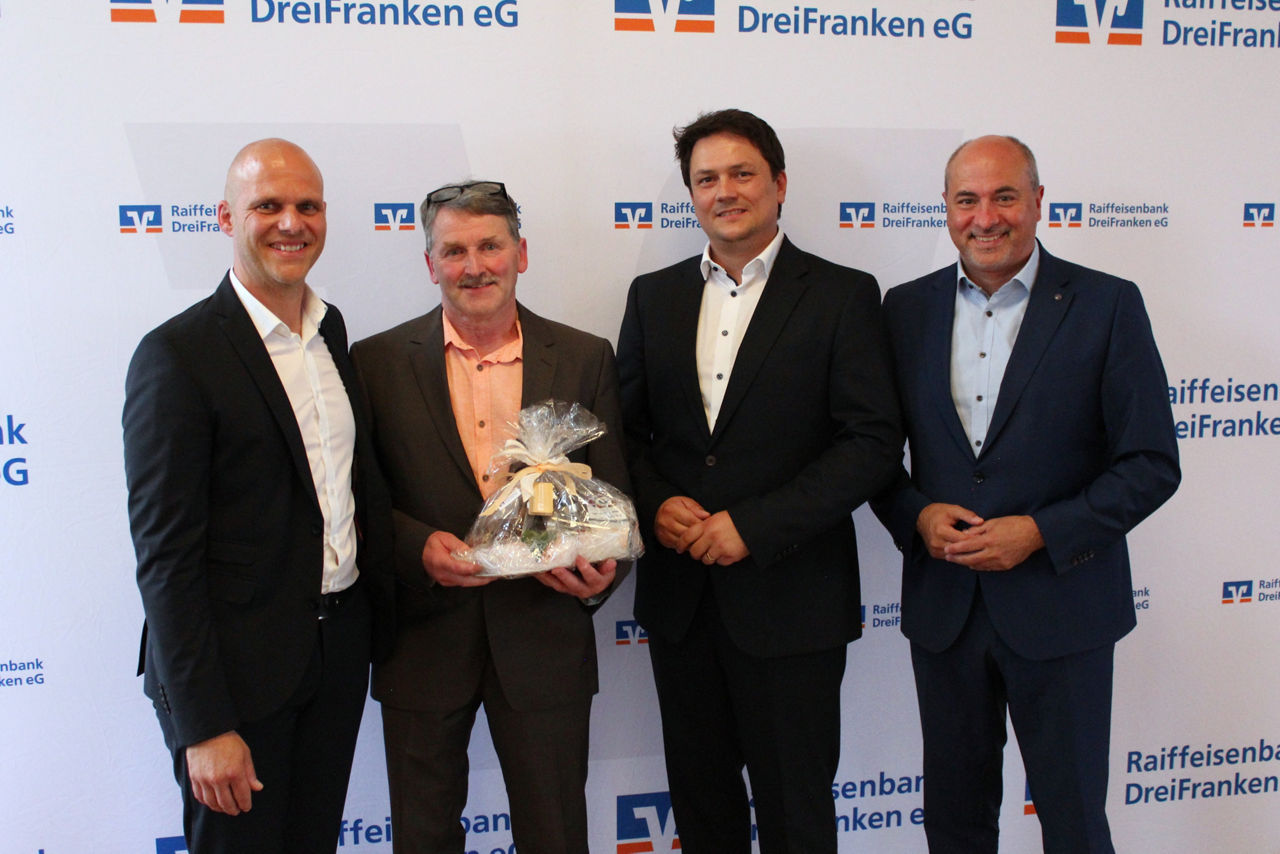 Andreas Heilmann, Siegfried Hummel, Stefan Gebhardt und Johannes Krapp stehen vor einer Fotowand