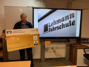ein Mann hält einen Preis vor einem Videoprojektor