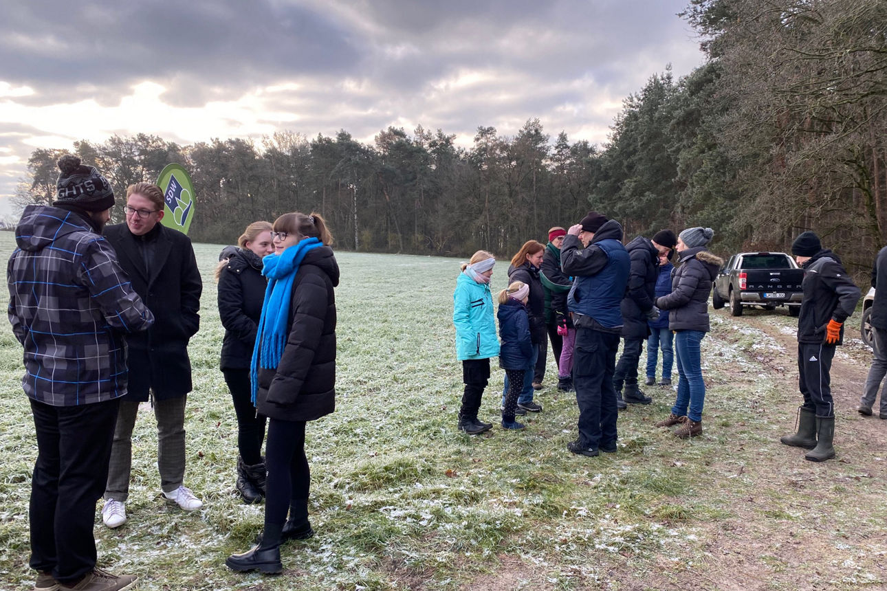 Mitarbeiter treffen sich am Waldrand.