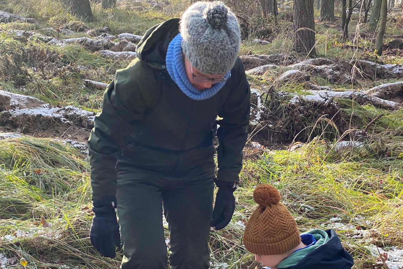 Mutter begutachtet das Loch für einen Sätzling mit ihrem Kind