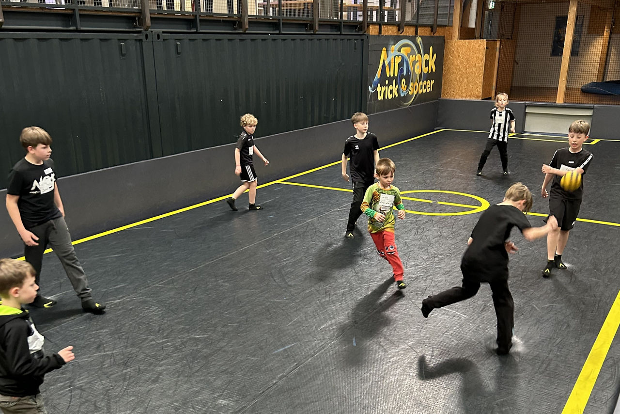 Kinder spielen Fußball im Innenbereich