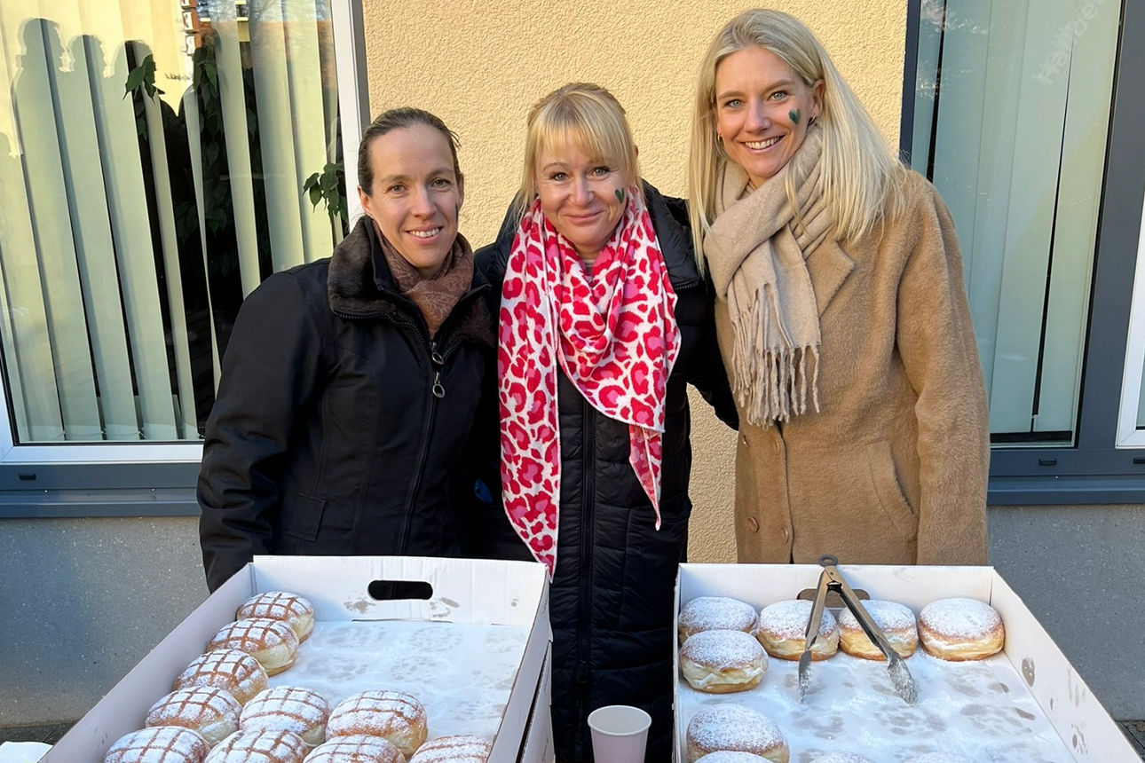 Kolleginnen verteilen Krapfen