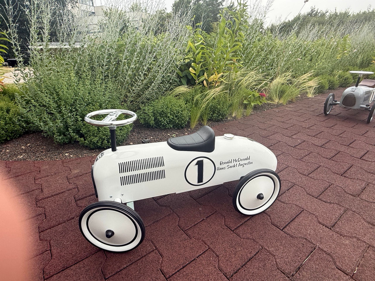 Ein Bobbycar auf einem gepflasterten Weg.
