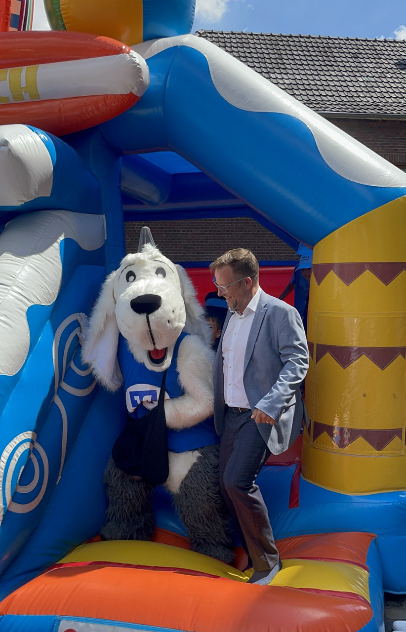 Filialleiter Stefan Jansen mit Maskottchen Sam auf der Hüpfburg