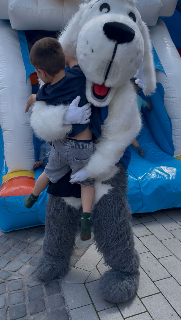 Maskottchen Sam umarmt ein Kind