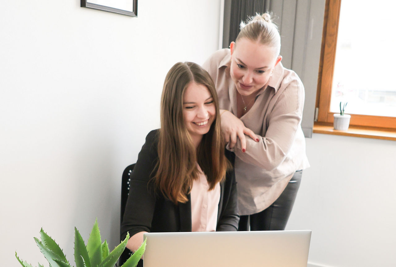 Zwei Damen sitzen vor einem Laptop