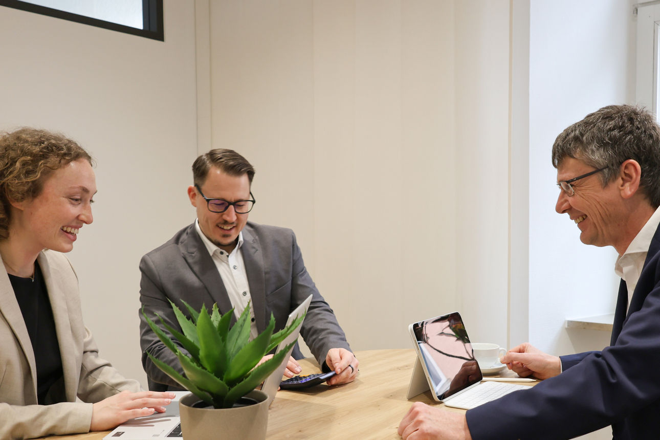 Eine Frau und zwei Herren arbeiten gemeinsam an einem Projekt