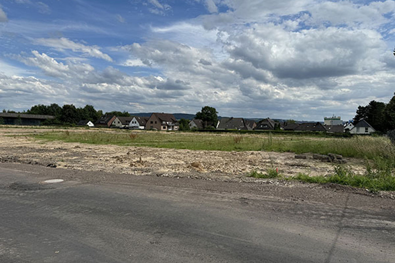 Foto von der Straße im Baugebiet mit Häusern im Hintergrund