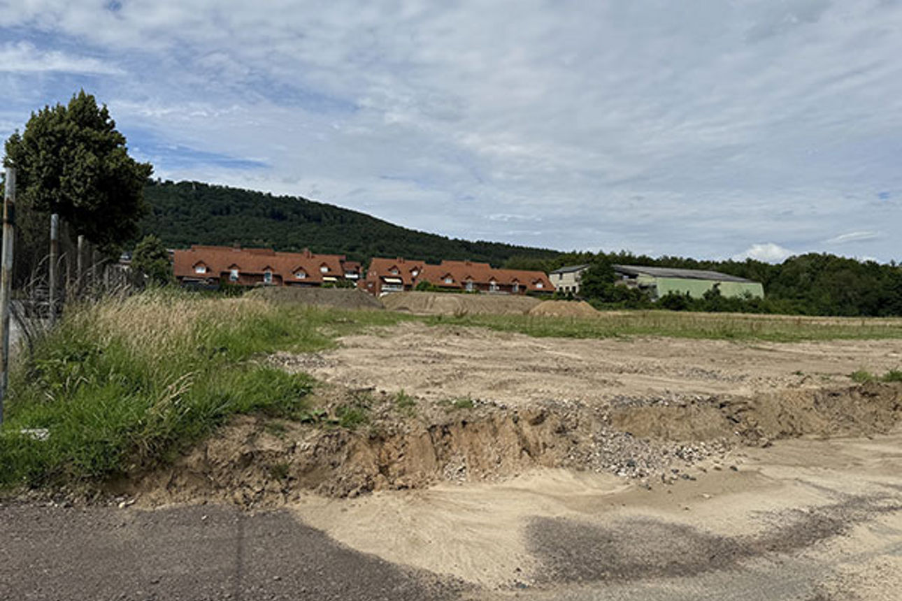 Foto von der Straße im Baugebiet mit Häusern im Hintergrund