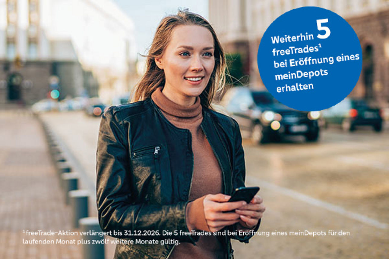 Junge Frau mit Smartphone in der Hand steht auf der Straße und lächelt