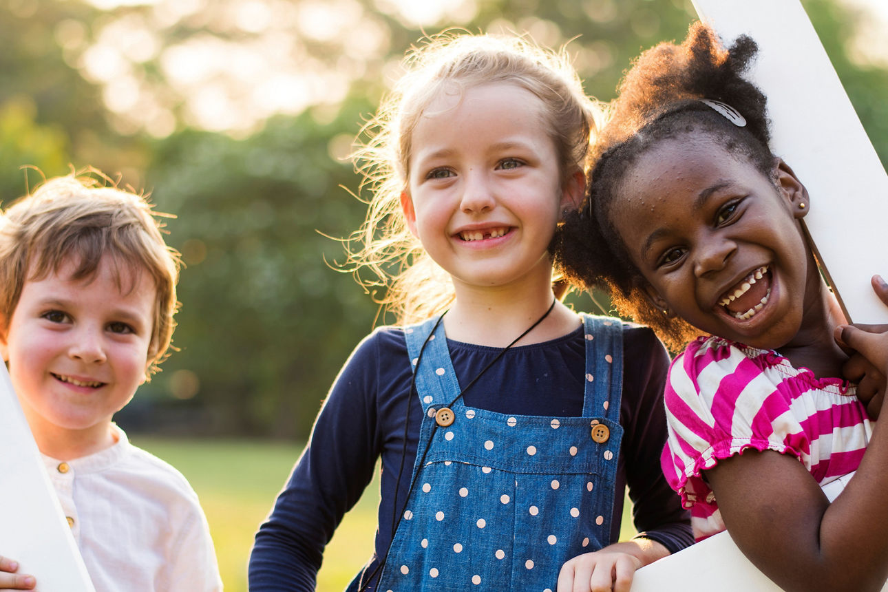 Drei Kinder, die draußen zusammen Spaß haben